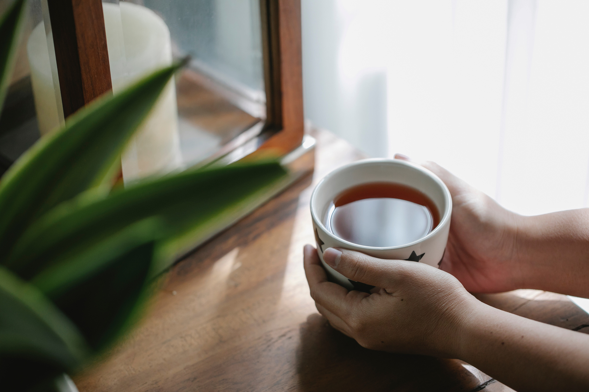 Crop person with cup of tea